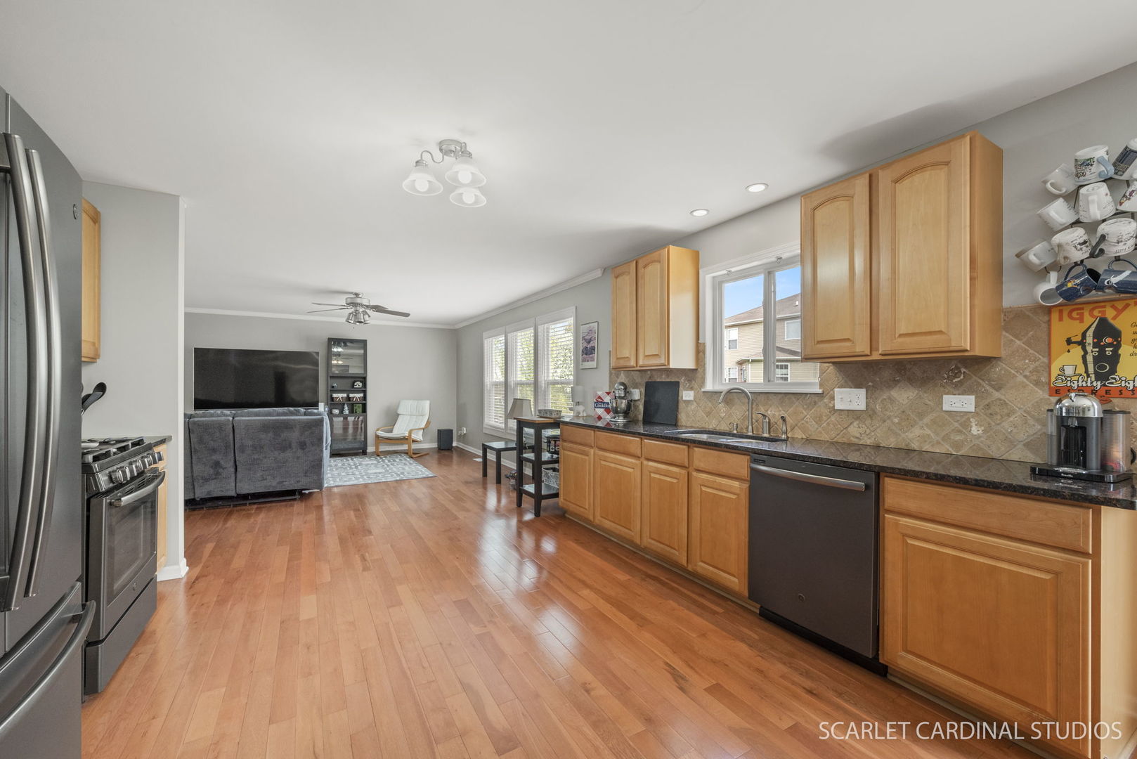 3214 Marbill Farm Road Montgomery, IL 60538 - Photo 3 of 27 a large living room with stainless steel appliances granite countertop couches a flat screen tv and a refrigerator