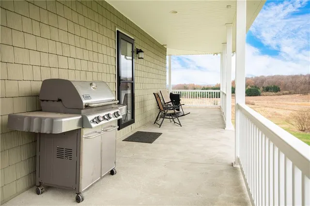 a view of living room with barbeque grill and floor to ceiling window