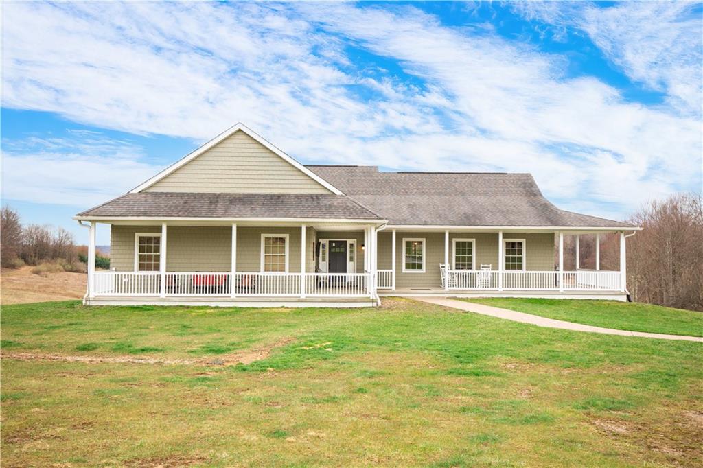 262 Windy Point Road Harrisville, PA 16038 - Photo 2 of 38 a front view of a house with a garden and trees