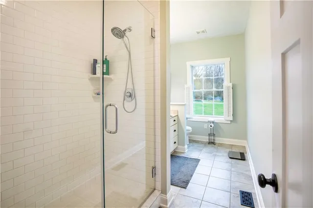 a bathroom with a granite countertop shower a toilet and a sink