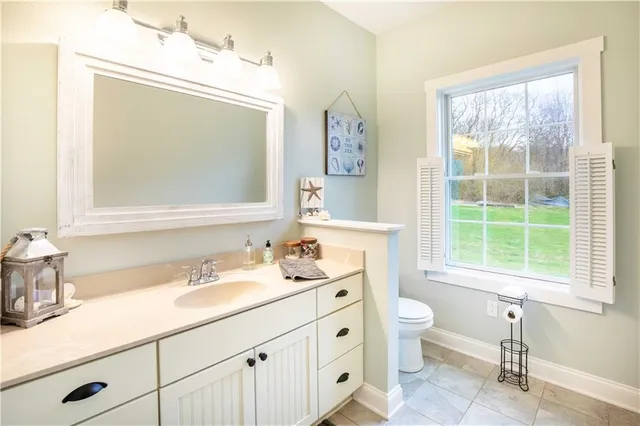 a bathroom with a double vanity sink toilet and a mirror