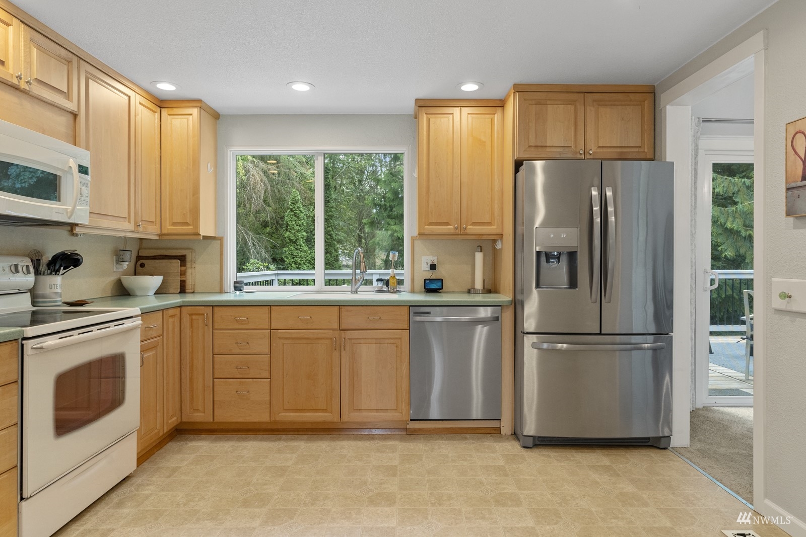 9651 Northeast 201st Street Bothell, WA 98011 - Photo 14 of 39 a kitchen with stainless steel appliances granite countertop a refrigerator a sink a stove a microwave and cabinets