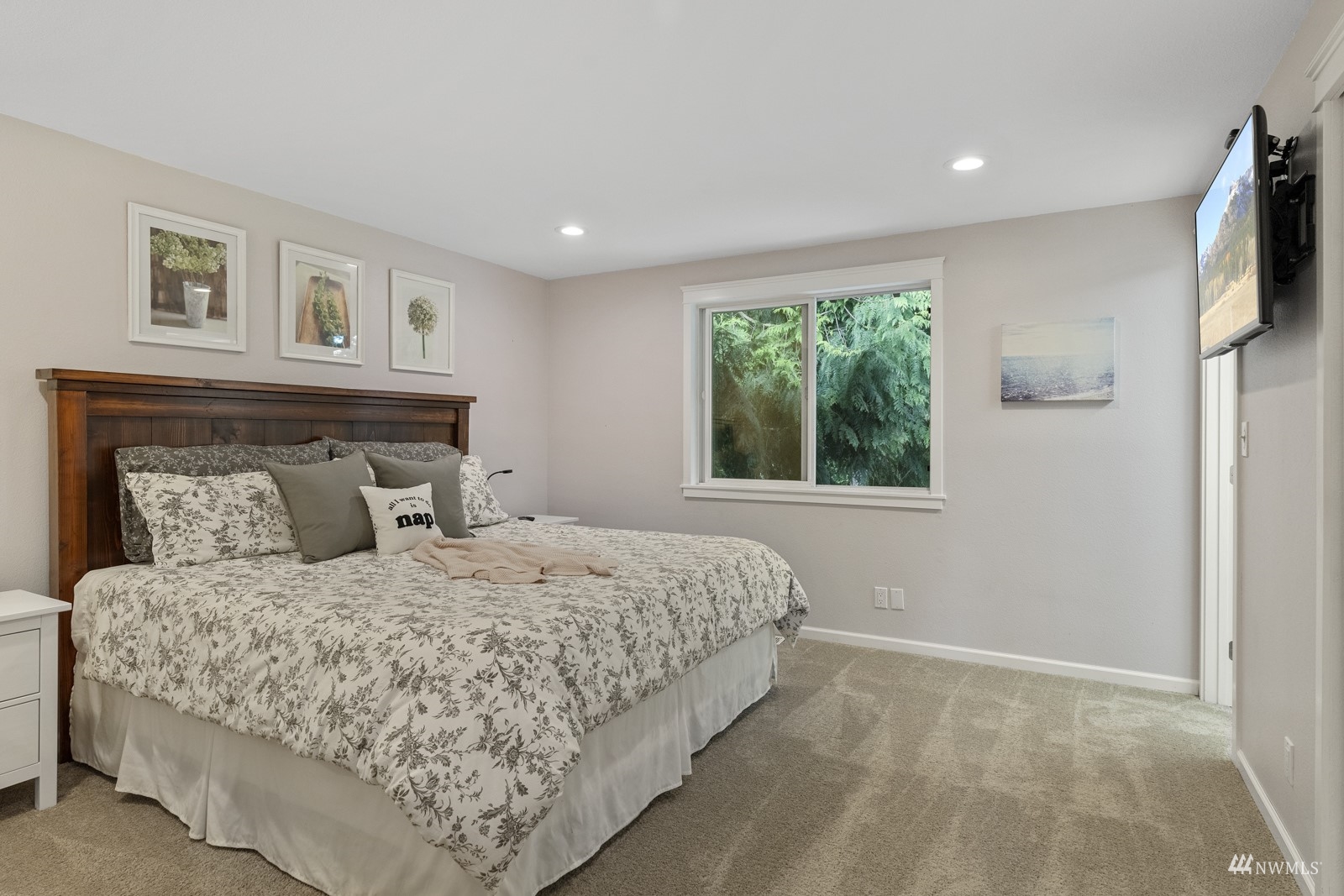 9651 Northeast 201st Street Bothell, WA 98011 - Photo 19 of 39 a bedroom with a large bed and a flat tv screen