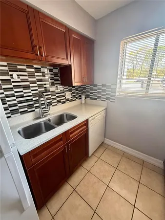 a kitchen with a sink cabinets and window