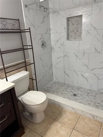 a white toilet sitting next to a shower