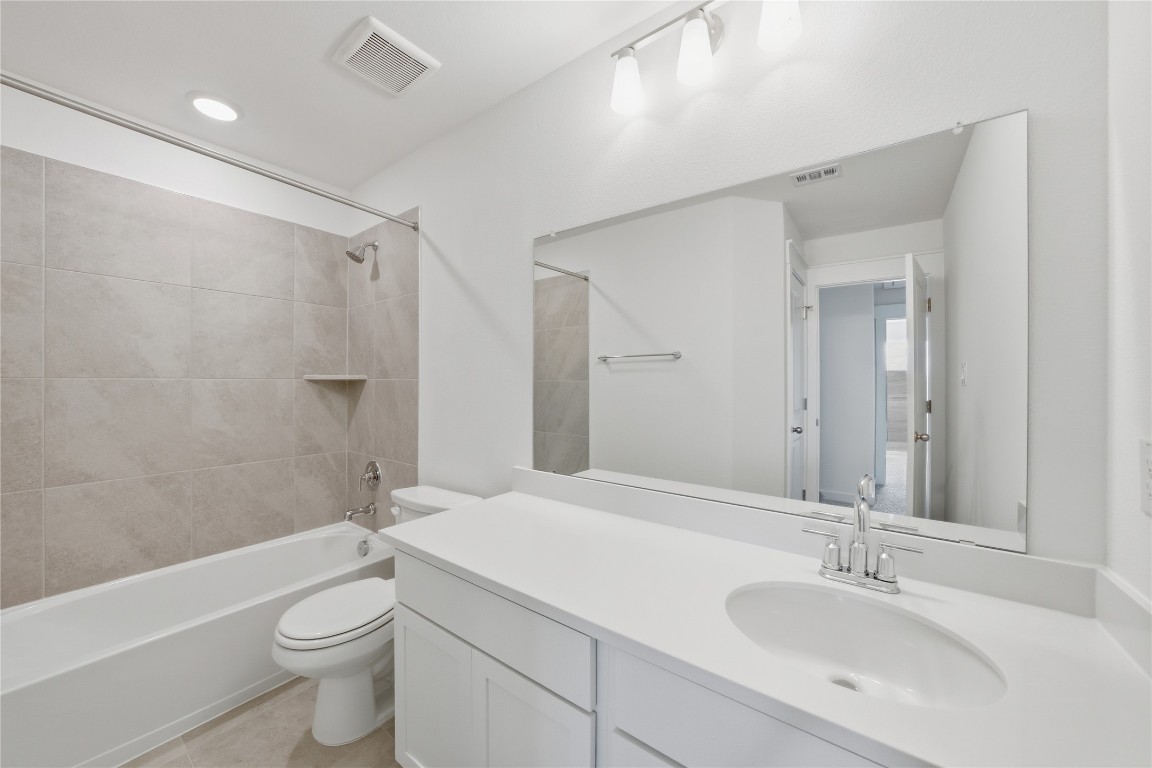 13501 Barn Chime Street Elgin, TX 78621 - Photo 11 of 19 a bathroom with a sink a toilet and shower