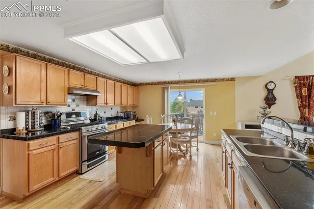 a kitchen with a sink stove top oven and cabinets
