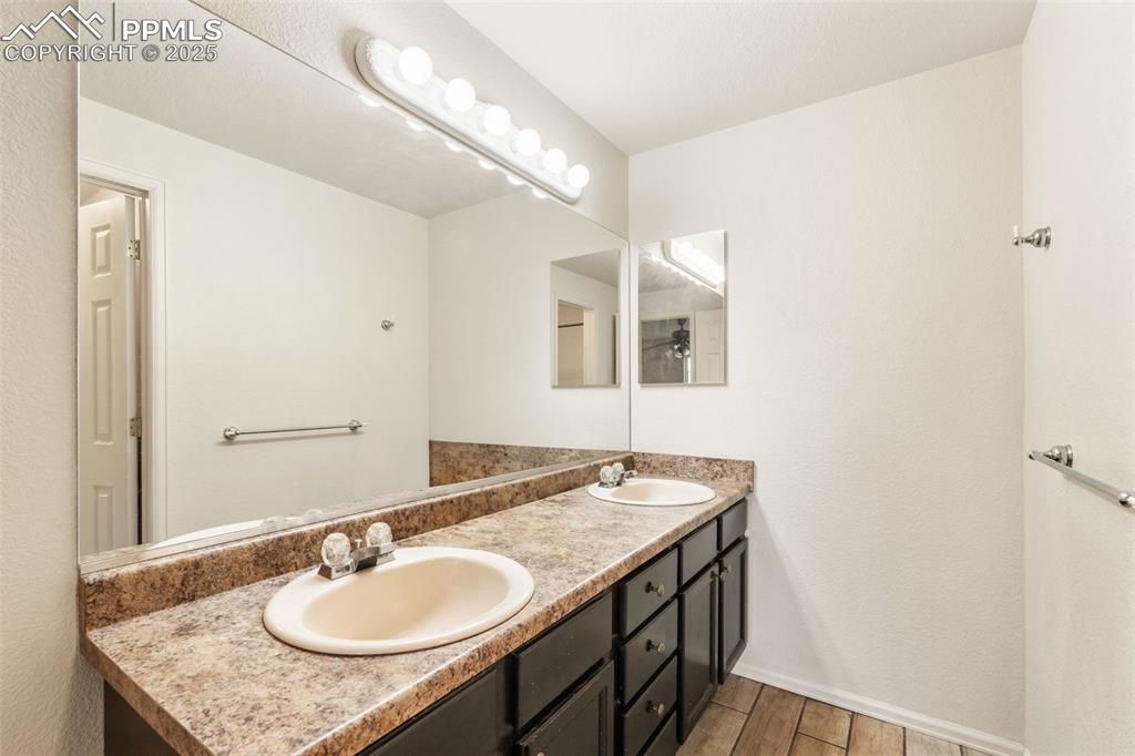 8654 Champie Road Peyton, CO 80831 - Photo 32 of 40 a bathroom with a granite countertop sink and a mirror