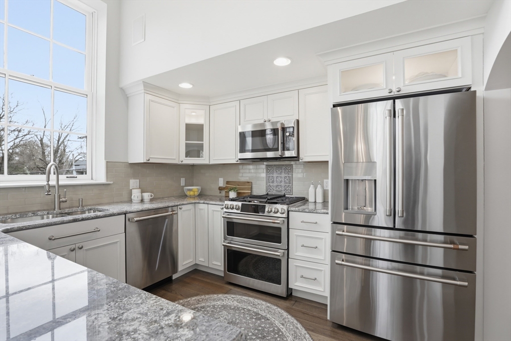 83 Church Street, Unit 15 Winchester, MA 01890 - Photo 12 of 34 a kitchen with stainless steel appliances a refrigerator sink and microwave
