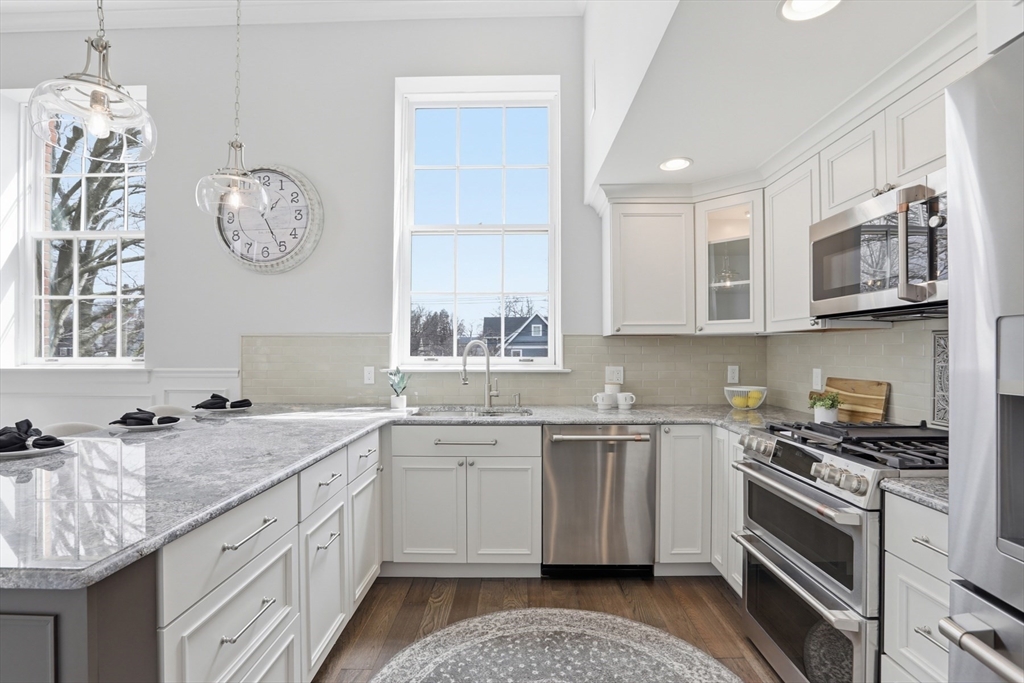 83 Church Street, Unit 15 Winchester, MA 01890 - Photo 13 of 34 a kitchen with stainless steel appliances granite countertop a sink and a stove