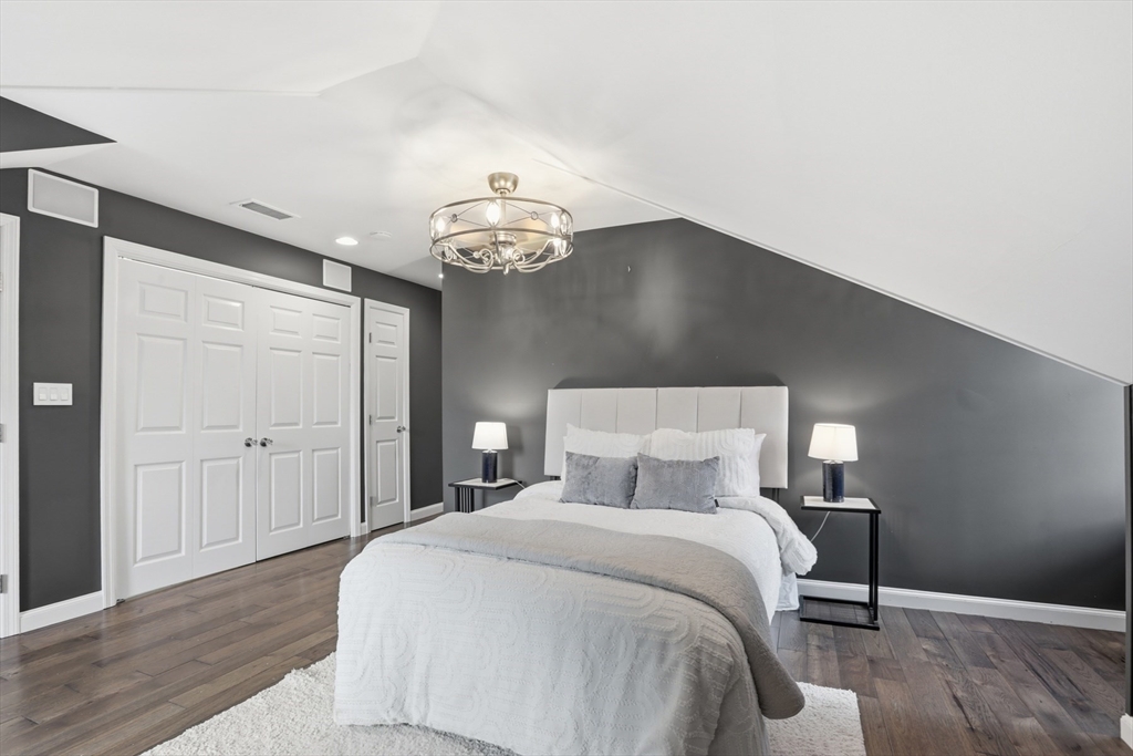 83 Church Street, Unit 15 Winchester, MA 01890 - Photo 19 of 34 a bedroom with a bed and a chandelier
