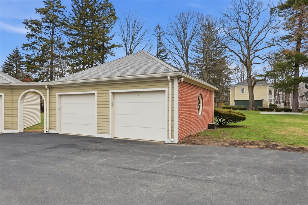 83 Church Street, Unit 15 Winchester, MA 01890 - Photo 29 of 34 a front view of house with garage and yard