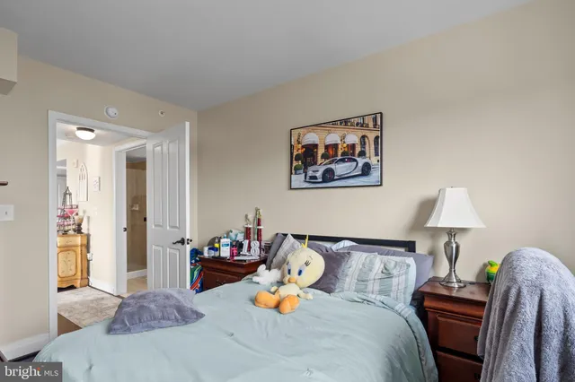 a bedroom with a bed and a lamp on dresser