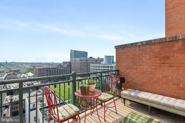 a balcony with outdoor seating and city view