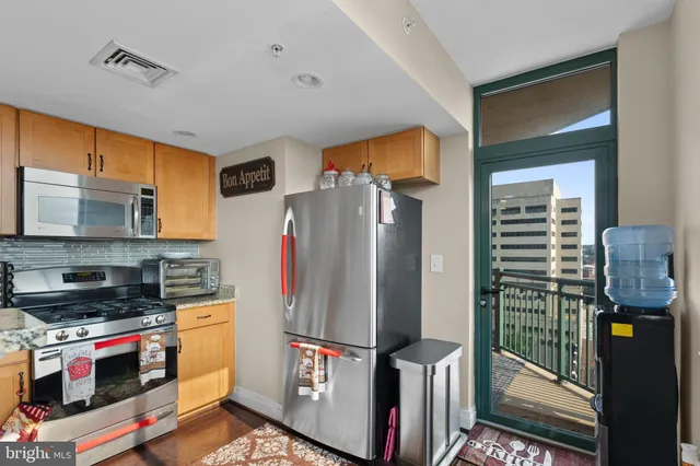 a kitchen with stainless steel appliances a refrigerator and a stove top oven