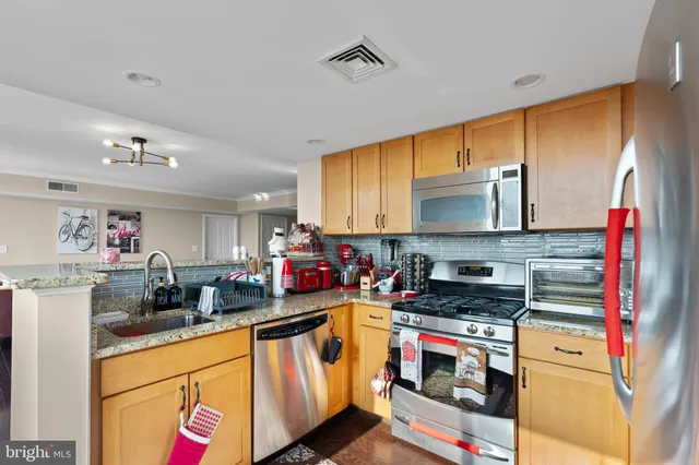 a kitchen with stainless steel appliances a stove a sink and a microwave