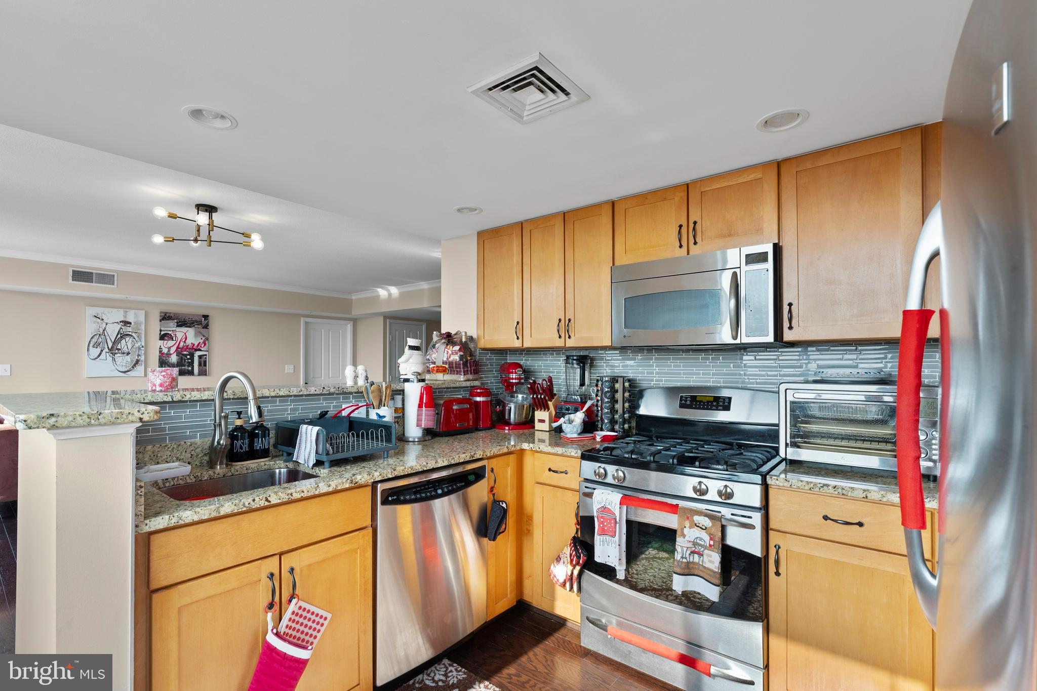 414 Water Street, Unit 1112 Baltimore, MD 21202 - Photo 24 of 40 a kitchen with stainless steel appliances a stove a sink and a microwave