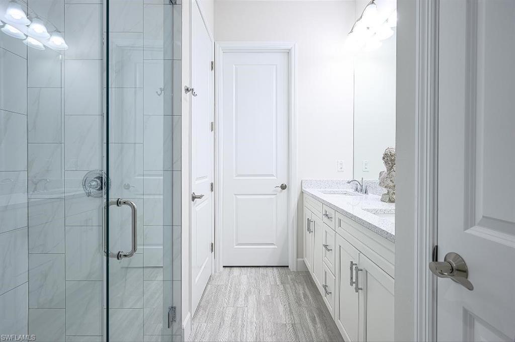 7164 Cayo Coco Lane Naples, FL 34113 - Photo 12 of 17 a bathroom with a granite countertop sink a toilet and shower