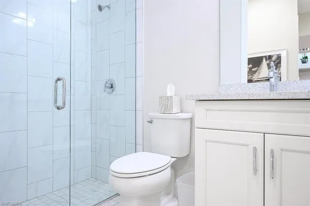 a bathroom with a toilet a sink a shower and mirror