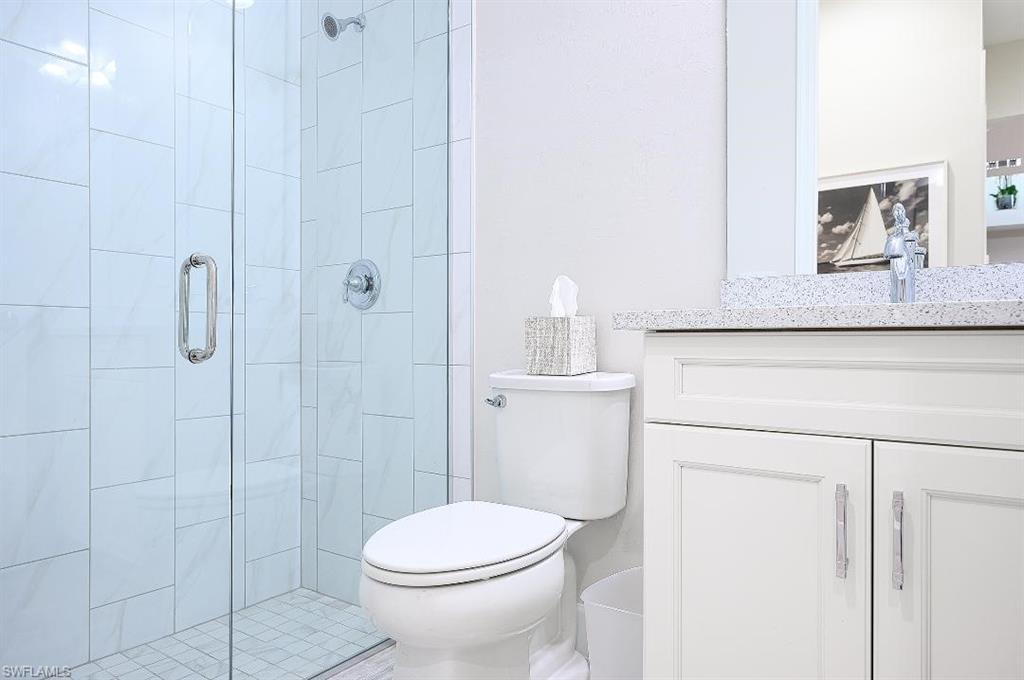 7164 Cayo Coco Lane Naples, FL 34113 - Photo 14 of 17 a bathroom with a toilet a sink a shower and mirror