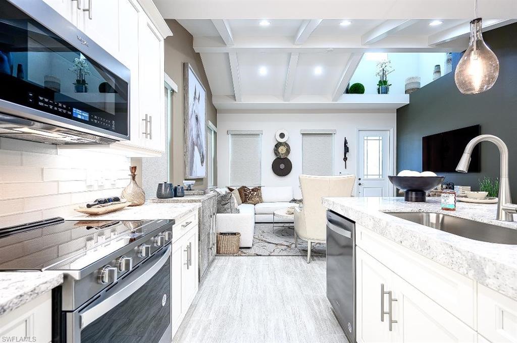7164 Cayo Coco Lane Naples, FL 34113 - Photo 7 of 17 a kitchen with a sink stove and wooden cabinets