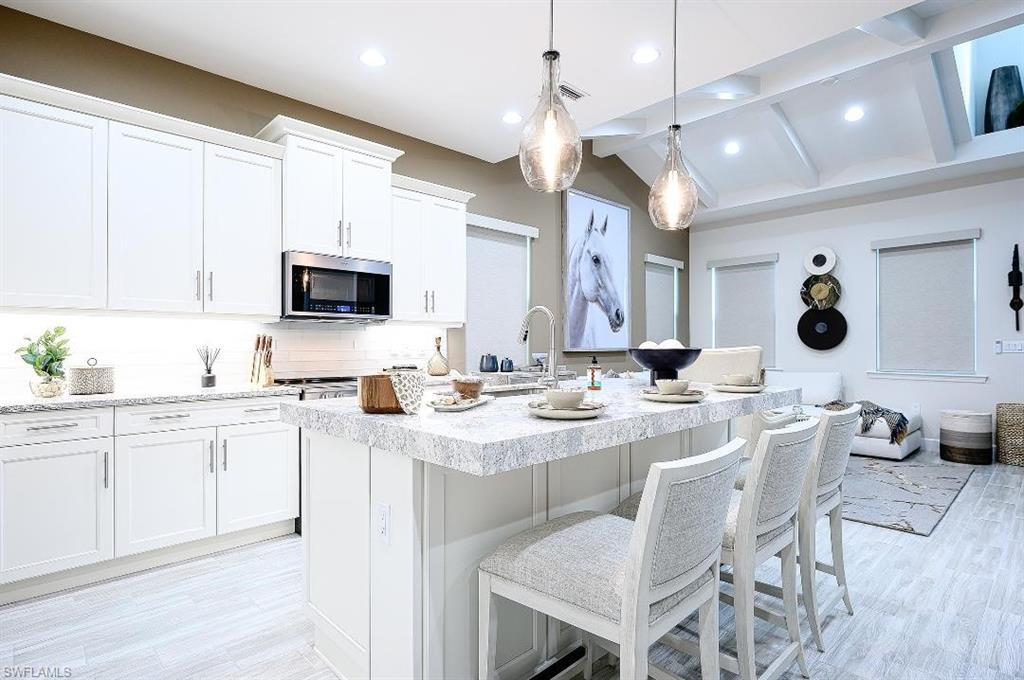 7164 Cayo Coco Lane Naples, FL 34113 - Photo 8 of 17 a large kitchen with a sink stainless steel appliances and dining table view