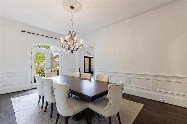 a kitchen with stainless steel appliances granite countertop a dining table chairs stove refrigerator and cabinets