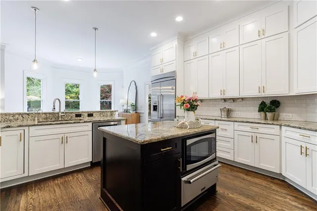 a spacious bathroom with a double vanity sink a toilet a mirror and shower