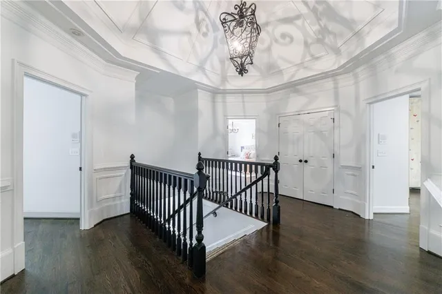 a backyard of a house with table and chairs a fire pit and a large tree