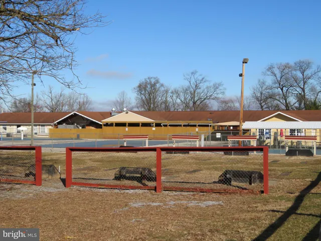 a view of a large pool with lawn chairs under an umbrella