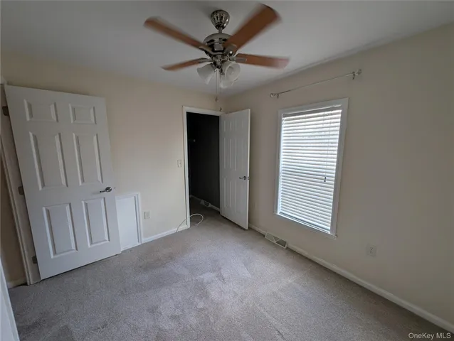 a view of a livingroom with a ceiling fan and window