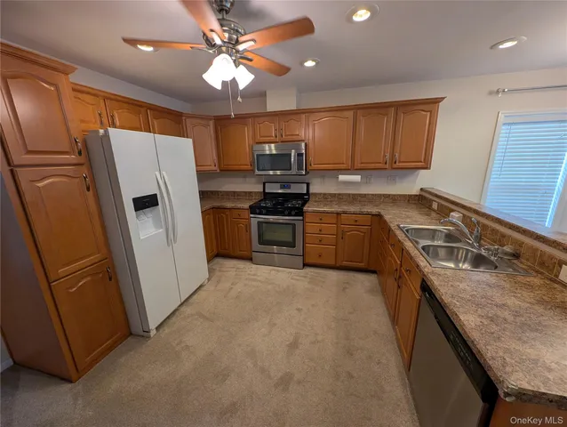 a kitchen with granite countertop a refrigerator stove and sink