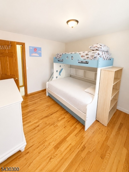 25 Spring Street, Unit A Millburn, NJ 07041 - Photo 13 of 21 a bedroom with a bed and wooden floor