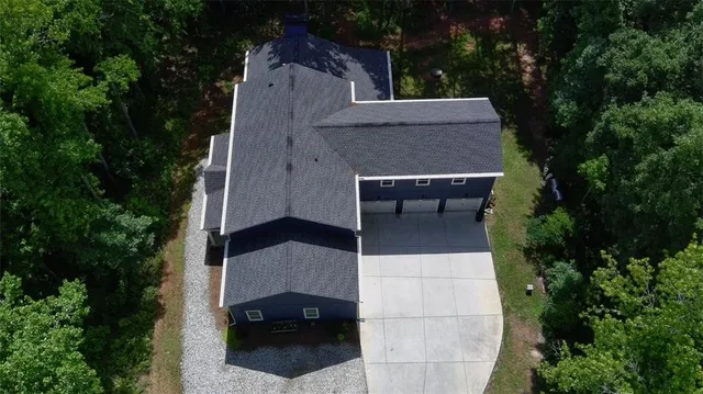 an aerial view of a house with balcony and trees