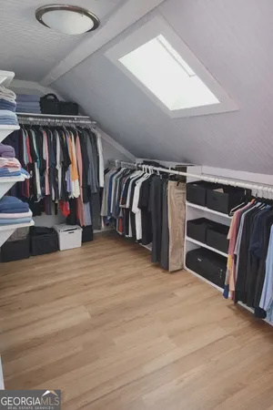 a view of walk in closet with clothes and shoes