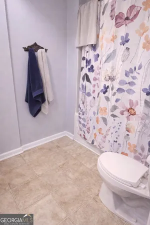 a bathroom with a toilet and a shower curtain