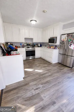 a kitchen with granite countertop a stove top oven and cabinets