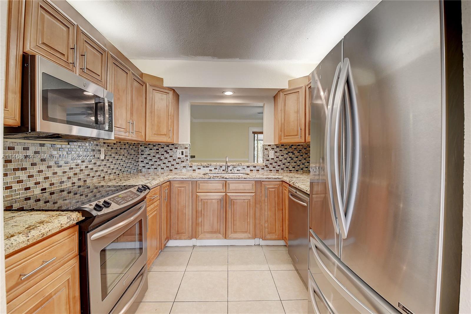 Sandalfoot Cove Boca Raton, FL 33428 - Photo 14 of 44 a kitchen with granite countertop a refrigerator and a sink