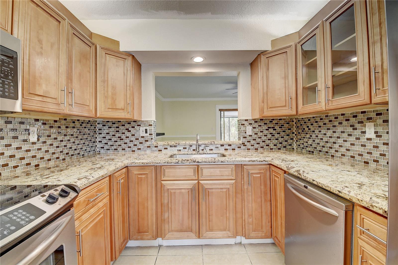 Sandalfoot Cove Boca Raton, FL 33428 - Photo 16 of 44 a kitchen with granite countertop a sink stove and cabinets