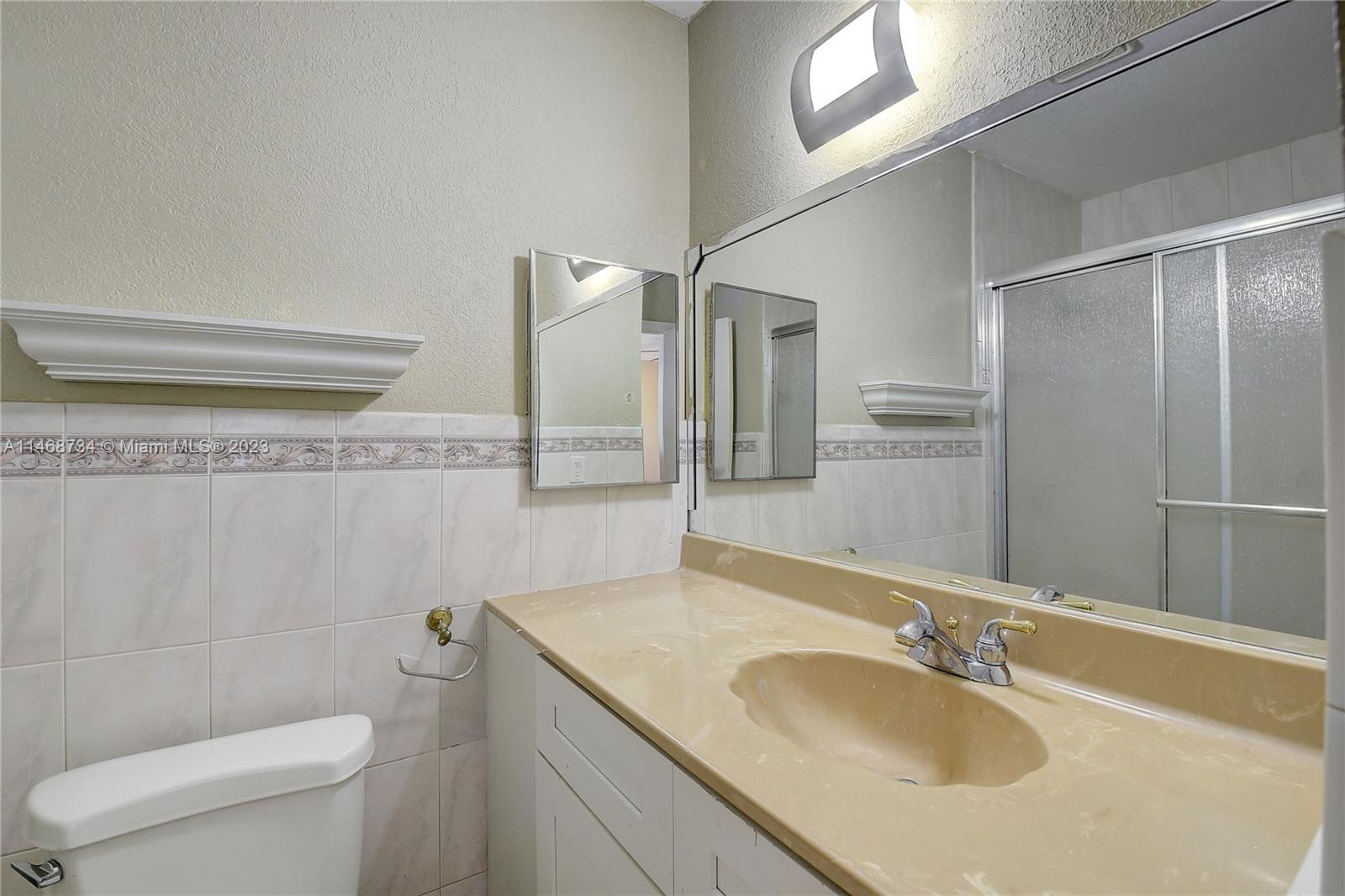 Sandalfoot Cove Boca Raton, FL 33428 - Photo 28 of 44 a bathroom with a granite countertop sink a toilet and a mirror