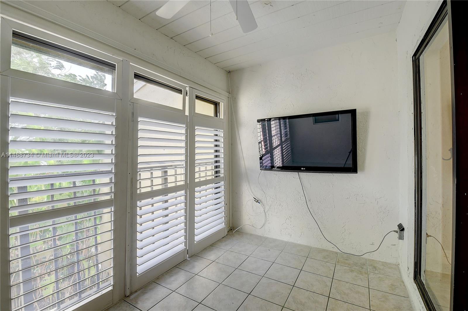 Sandalfoot Cove Boca Raton, FL 33428 - Photo 30 of 44 a living room with a flat screen tv and floor to ceiling window