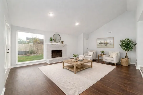a living room with furniture large window and a fireplace