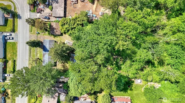 an aerial view of residential house with outdoor space and trees all around