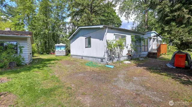 a view of a house with backyard and a tree