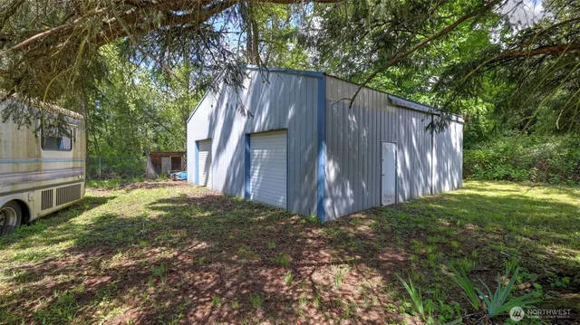 a view of backyard with wooden fence and large trees