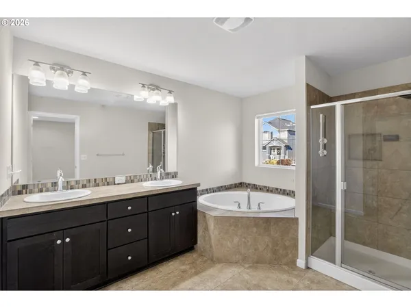 a spacious bathroom with a bathtub sink mirror and shower