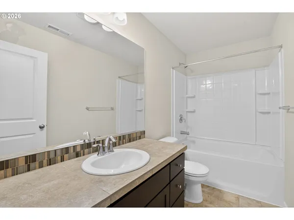 a bathroom with a sink toilet a mirror and shower