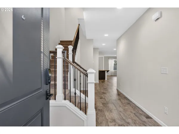 a view of a hallway with wooden floor and staircase