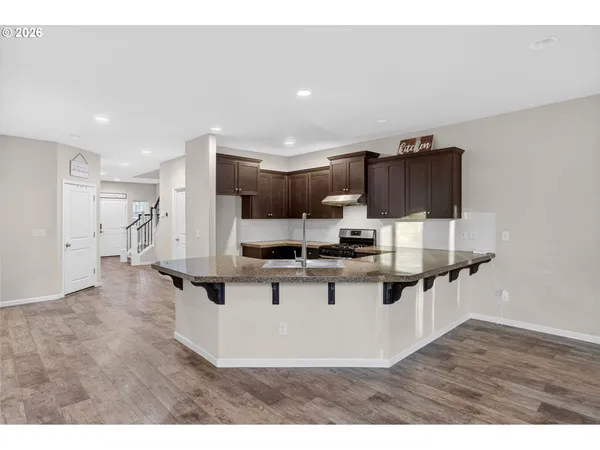 a view of kitchen with refrigerator stove microwave and wooden floor