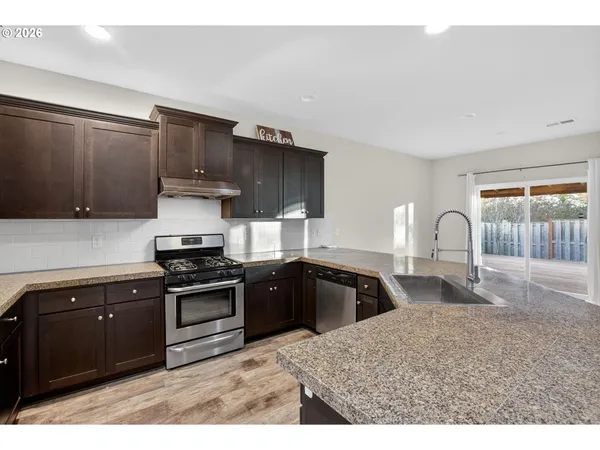 a kitchen with stainless steel appliances granite countertop a stove a sink and a microwave
